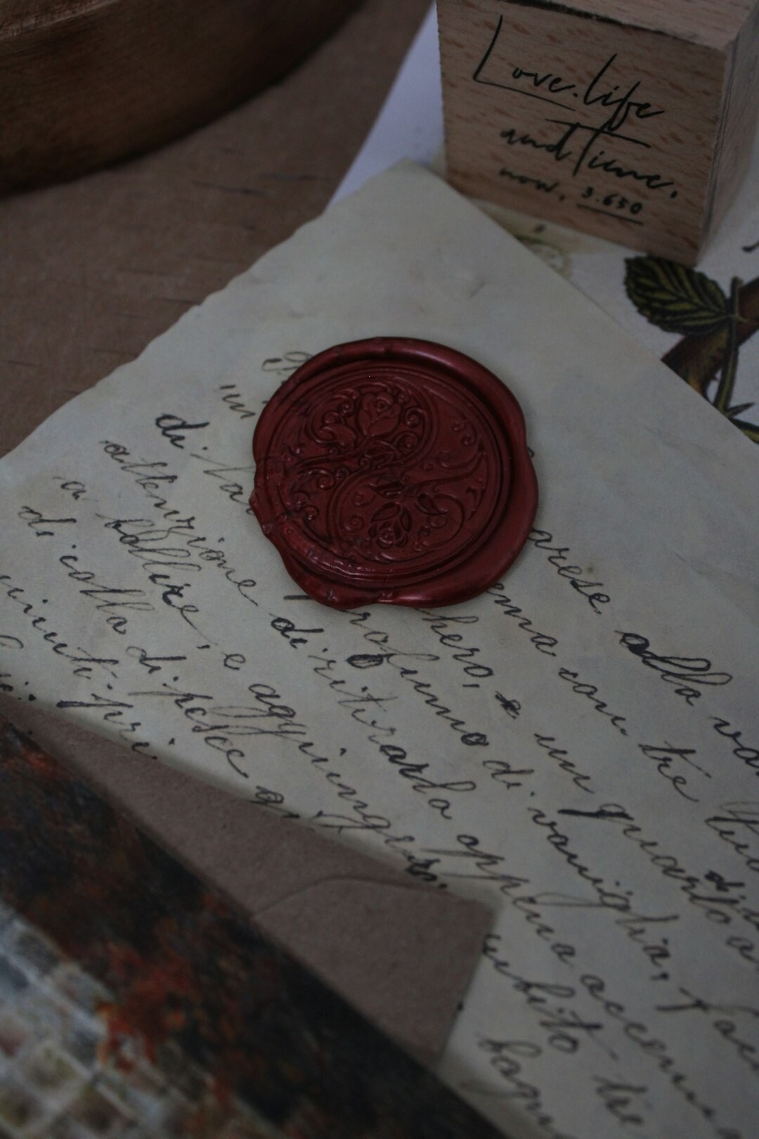 Old handwritten letter with a wax seal and quill pen on dark wood